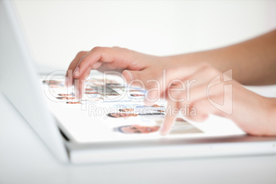 Close up of hands choosing pictures on a futuristic laptop