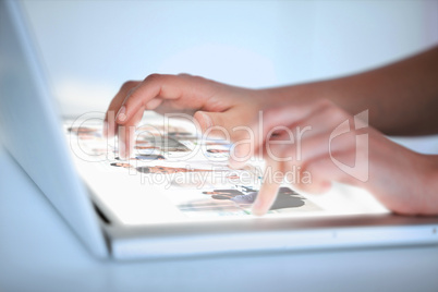 Close up of hands selecting pictures on a futuristic laptop