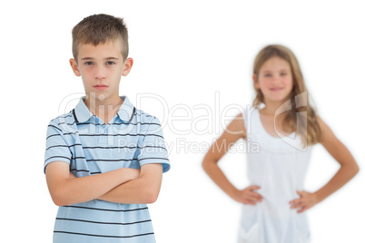 Serious child posing while his sister smiling