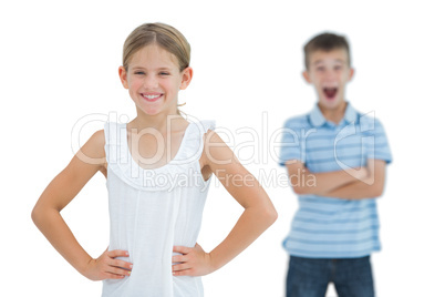 Cute young girl posing while her brother being shocked