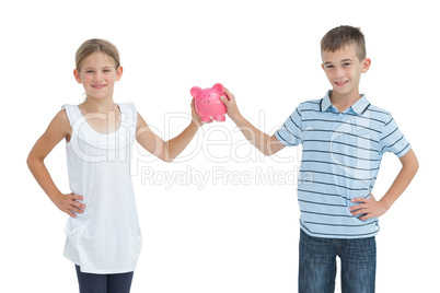 Brother and sister holding piggy bank together