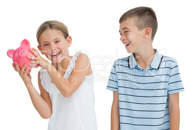 Smiling young girl holding piggy bank