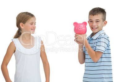 Smiling young boy holding piggy bank