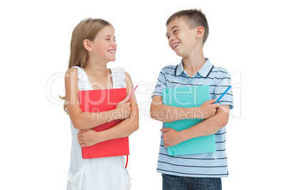 Smiling brother and sister holding their exercise books