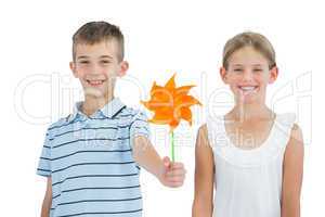 Smiling brother and sister playing with pinwheel