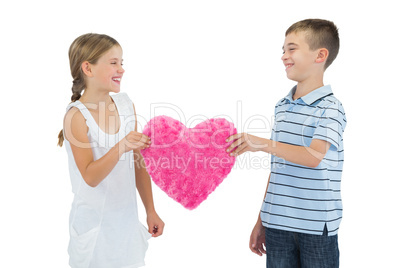 Smiling children holding heart shaped soft toy