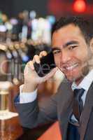 Happy businessman on the phone having a drink