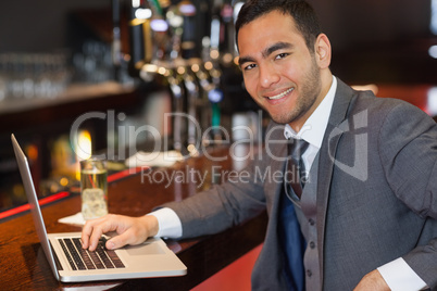 Smiling businessman working on his laptop