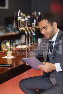 Smiling businessman working on his tablet computer
