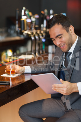 Cheerful businessman working on his tablet computer