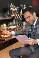 Cheerful businessman working on his tablet computer