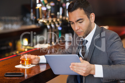 Serious businessman working on his tablet computer