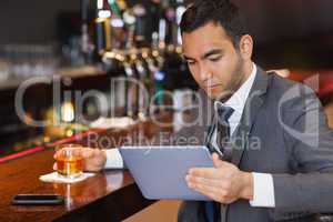 Serious businessman working on his tablet computer