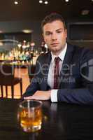 Serious businessman having a drink