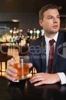 Thoughtful businessman having a drink
