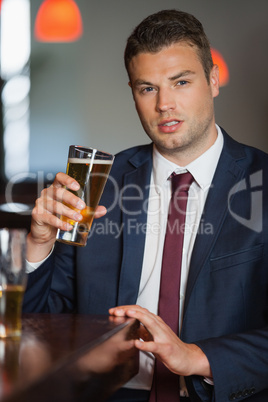 Handsome businessman having a pint