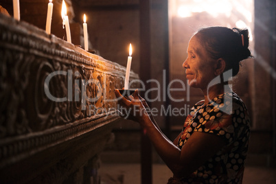 Asian woman praying with candle light