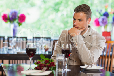 Handsome man waiting for his girlfriend at restaurant