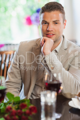 Smiling handsome man waiting for his girlfriend at restaurant