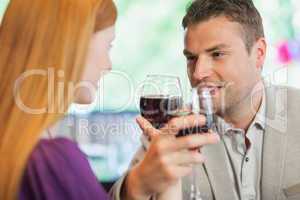 Handsome man having glass of wine with his girlfriend