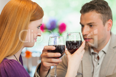 Handsome man having glass of wine with his pretty girlfriend