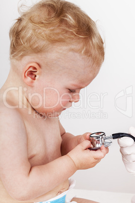 Child looks at the doctor's stethoscope
