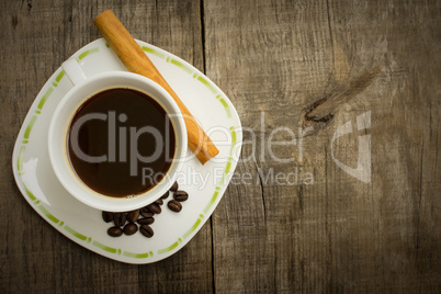 coffee cup with beans and cinnamon stick