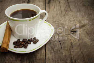 coffee cup with beans and cinnamon stick