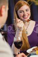 Pretty woman smiling at her husband during dinner