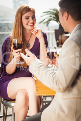 Smiling woman having glass of wine with her boyfriend