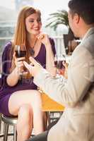 Smiling woman having glass of wine with her boyfriend