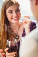 Cheerful woman having glass of wine with her boyfriend