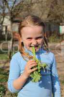little girl chewing young sprout of a rhubard