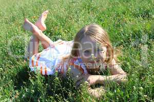 little girl lying on the grass