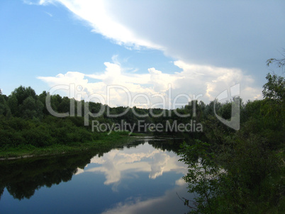 evening summer landscape with white clouds and river