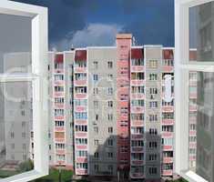 opened window to the multistorey house and big raincloud