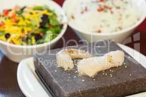 Prawn and white fish on hot stone for cooking