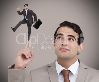 Businessman showing shrunk colleague dancing on his finger