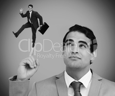 Thoughtful businessman showing shrunk colleague dancing on his f