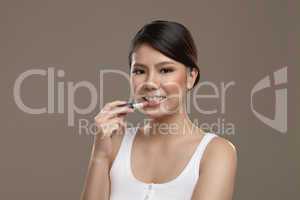 female asian applying lipstick