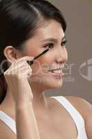 female asian applying mascara