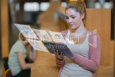 Pretty blonde student working on her digital tablet