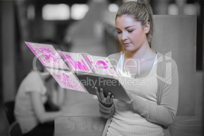 Pretty blonde student working on her futuristic tablet pc