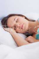 Brunette woman asleep in bed