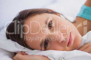 Woman lying in bed looking into the camera