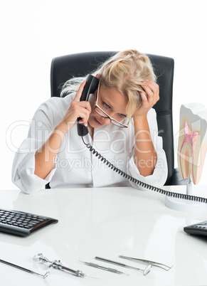 Ärztin telefoniert am Schreibtisch