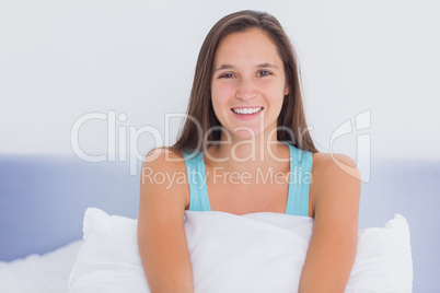 Young woman sitting on bed