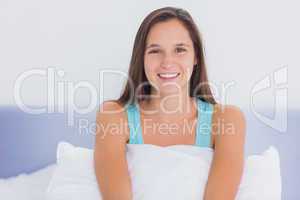 Young woman sitting on bed
