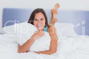 Smiling woman lying in bed