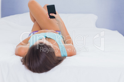 Woman on bed holding phone